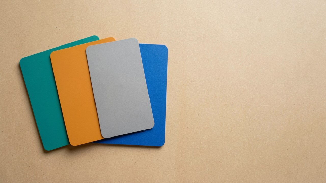A row of several different unmarked credit cards laid out on a table, viewed from above.